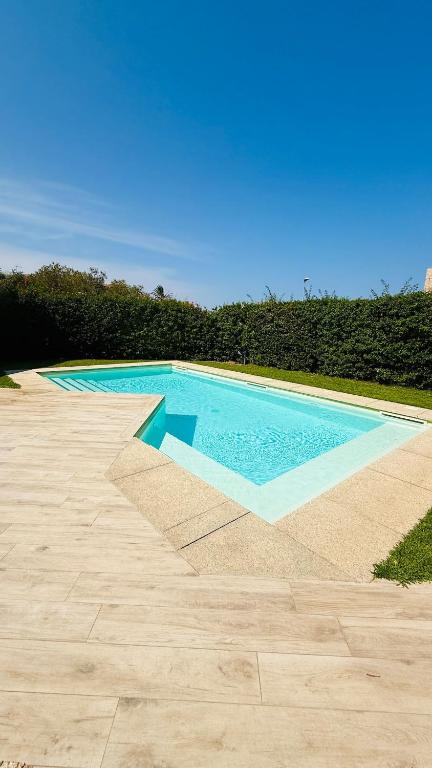 a large swimming pool with a blue at Casa Paradiso La Cinta San Teodoro in San Teodoro