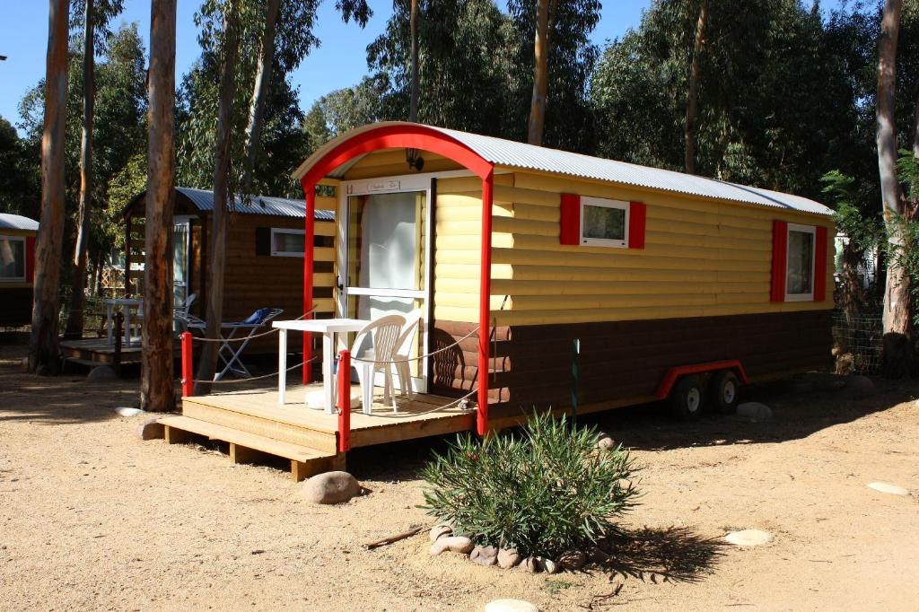 a yellow and red tiny house sitting in the dirt at Camping A Torra in Galeria