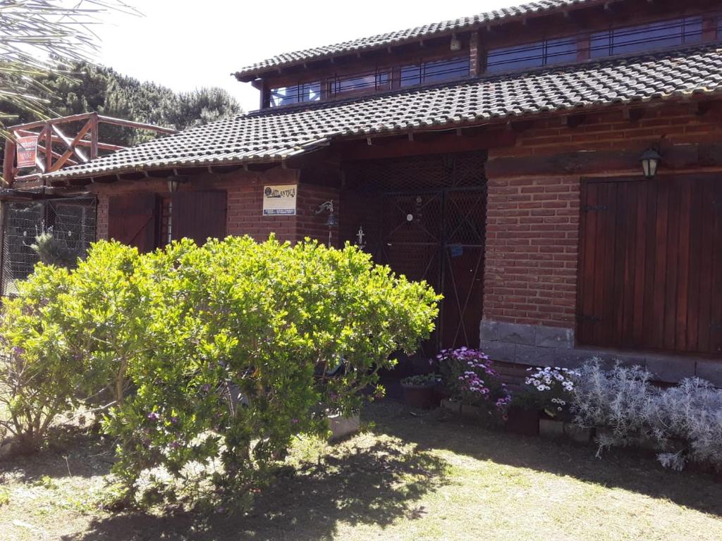 a brick house with flowers in front of it at Complejo Rancho Grande in Nueva Atlantis