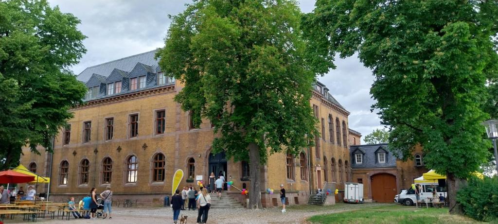 a large brick building with people standing in front of it at BBZ Burg Weißensee in Weißensee