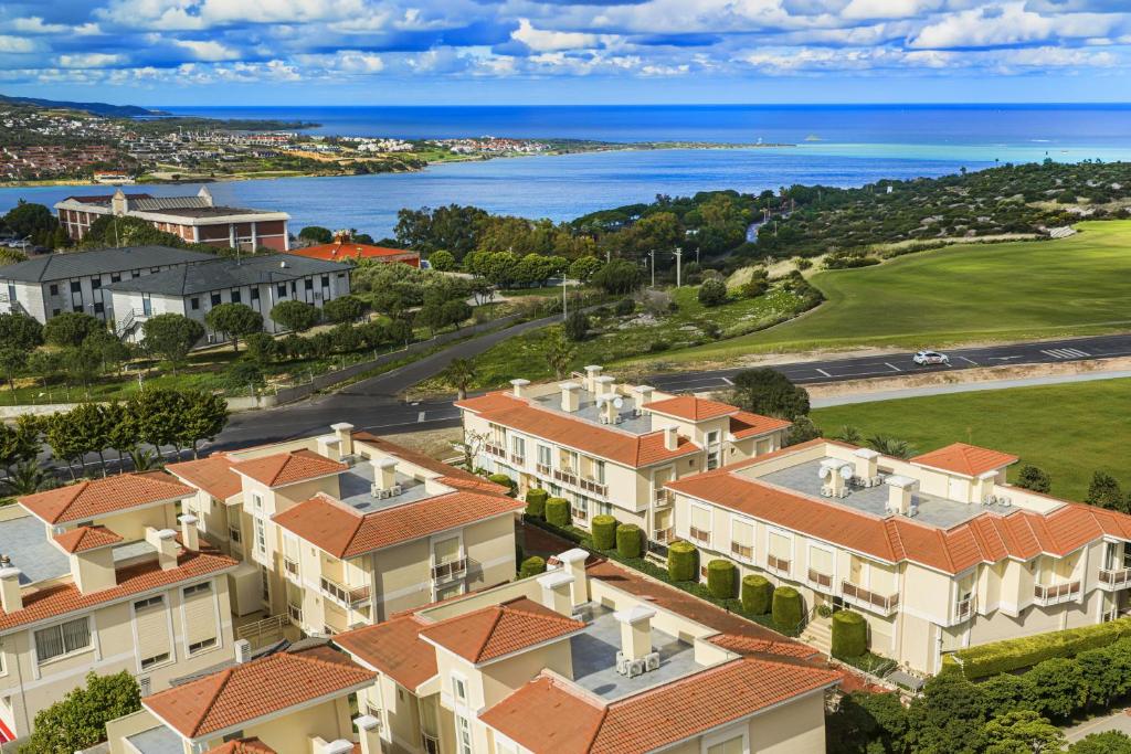 Eine Luftaufnahme eines Hauses mit dem Meer im Hintergrund in der Unterkunft Kamer Exclusive Hotel & Suites in Cesme