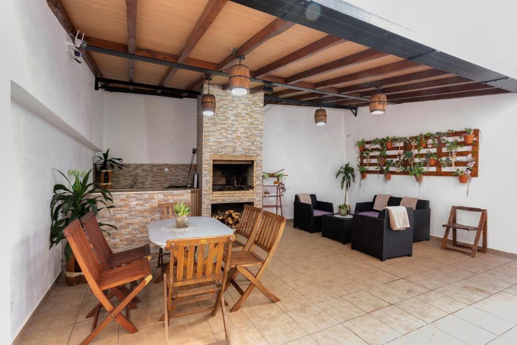 a living room with a fireplace and a table and chairs at Moradia Casa Feliz in Santa Cruz