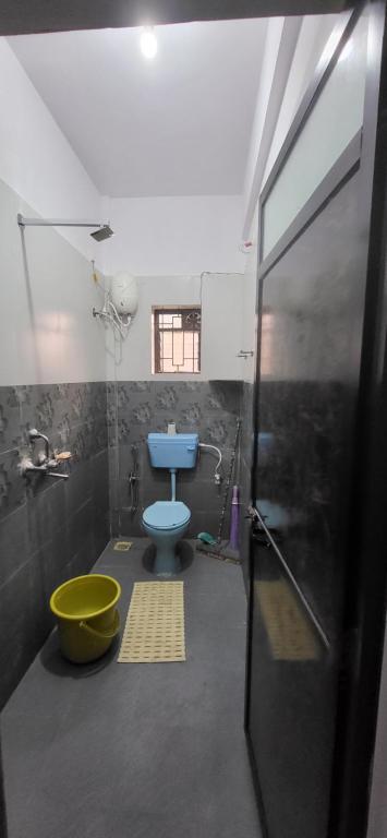 a bathroom with a blue toilet and a shower at Daji Dhabolkar house in Mandrem