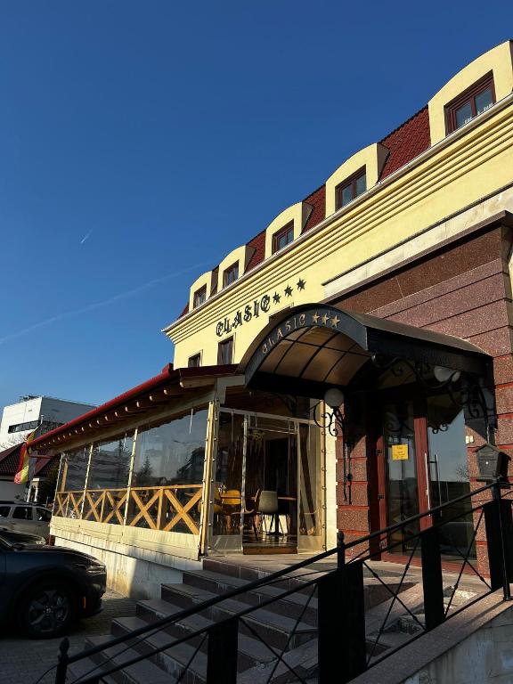 a restaurant with a sign on the side of a building at Hotel Clasic in Sebeş