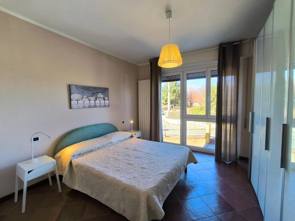 a bedroom with a bed and a large window at Villa la Tranquilla in Baveno