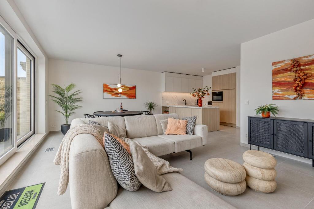 ein Wohnzimmer mit Sofa und Tisch in der Unterkunft Flat Scarpato in Kortemark