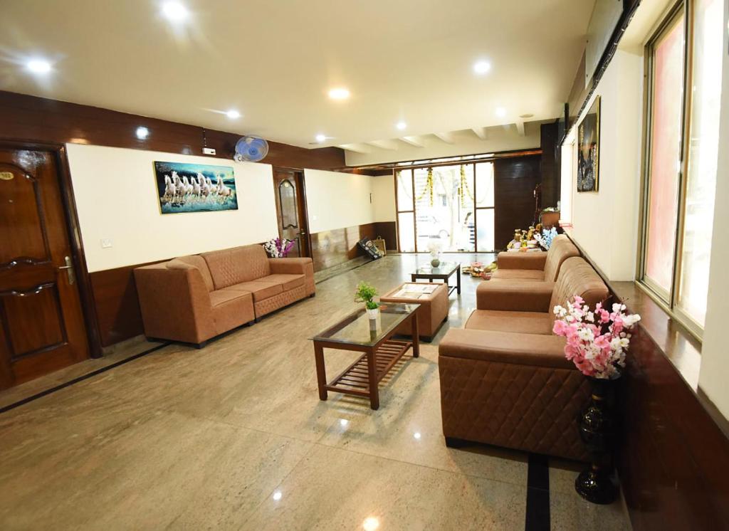 a large living room with couches and tables at Laavish 7 Hotel in Bangalore