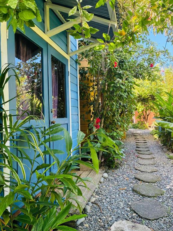 a house with a blue door and a garden path at Boathouse Bungalows By The Sea in Bocas Town