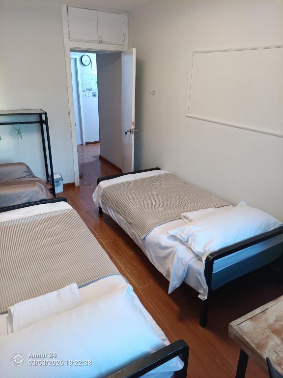 a room with two beds and a table and a door at Tsogoo Guesthouse Shared rooms in Ulaanbaatar