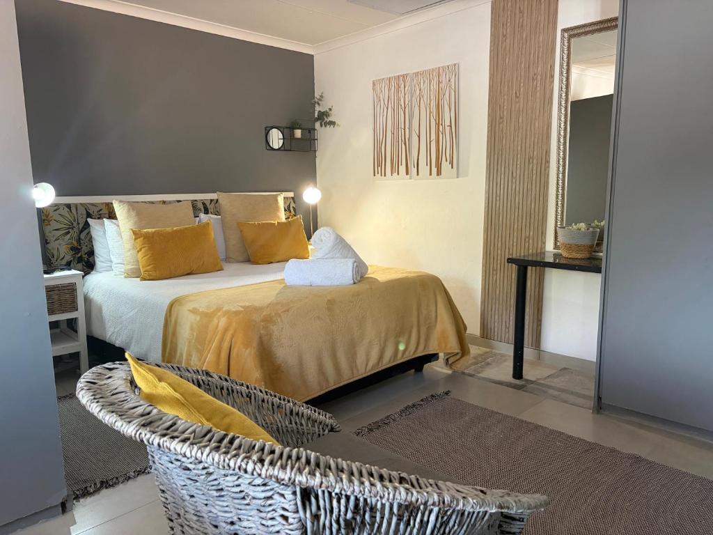 a bedroom with a bed with yellow pillows and a chair at Evening Star Guest Units in Fichardtpark