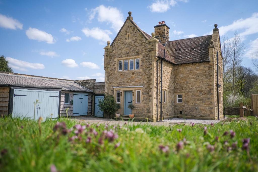 an old stone house with a garage at Costers Lodge in Midhurst