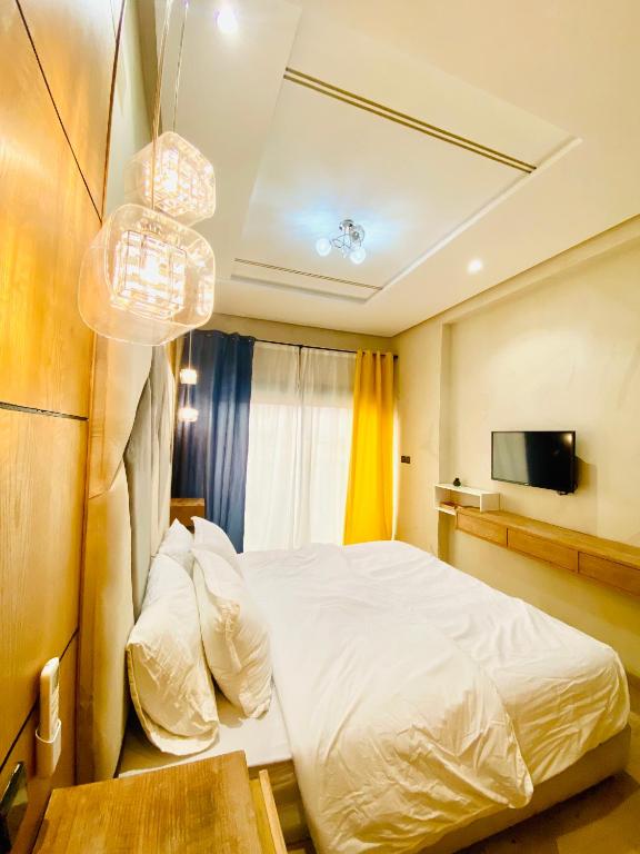 a bedroom with a white bed and a tv at New dream home in Fez