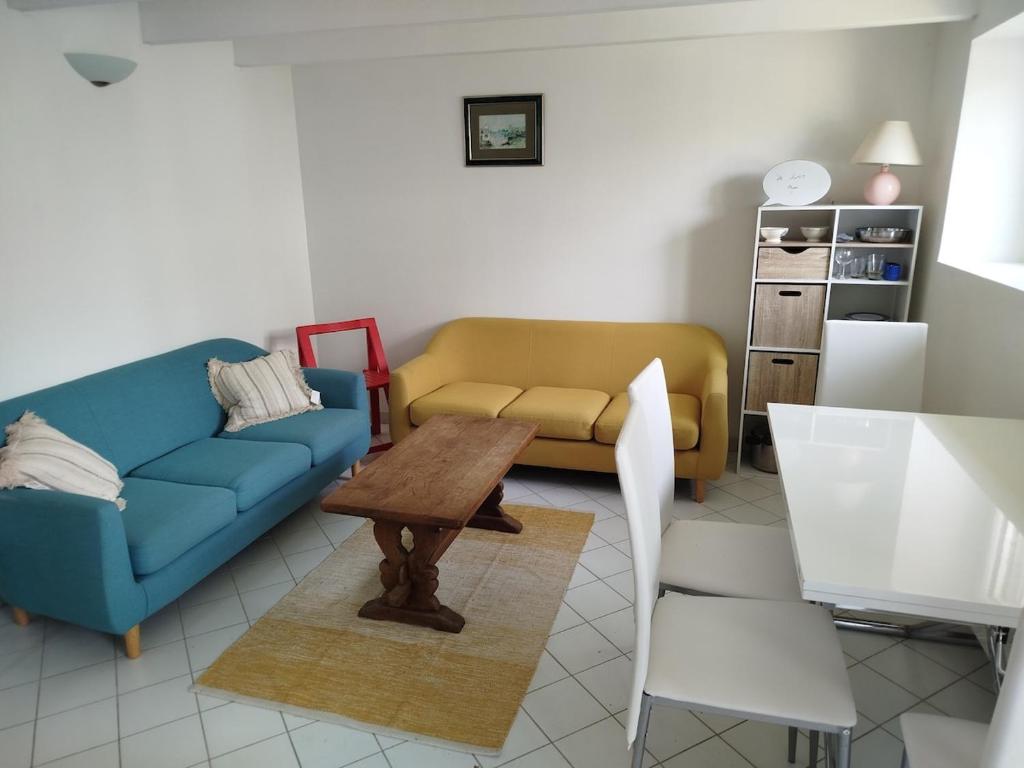 a living room with a blue couch and a table at Maison à L'île Grande in Pleumeur-Bodou