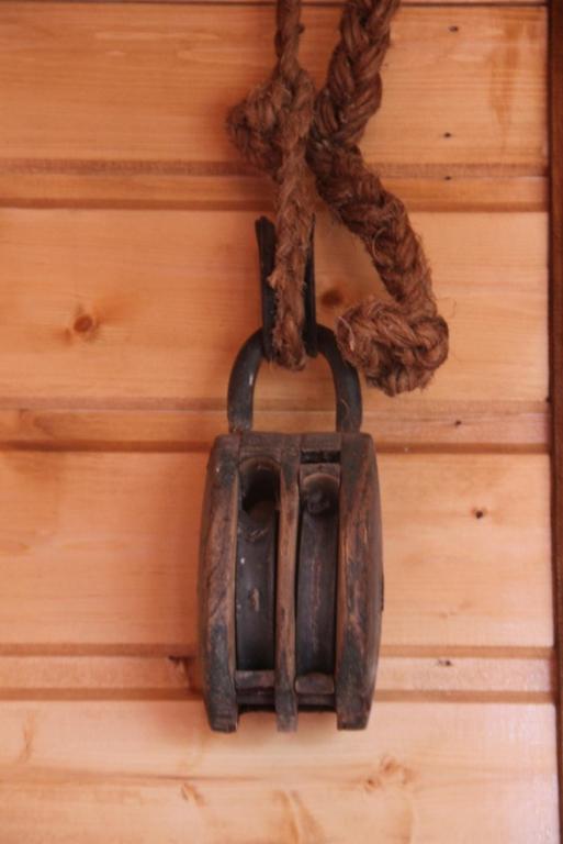 a object hanging on a wooden wall with a rope at Le Bellevue Honfleur in Honfleur