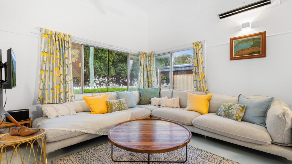 a living room with a couch and a table at White Cockatoo Beachfront Cottage in Newell Beach