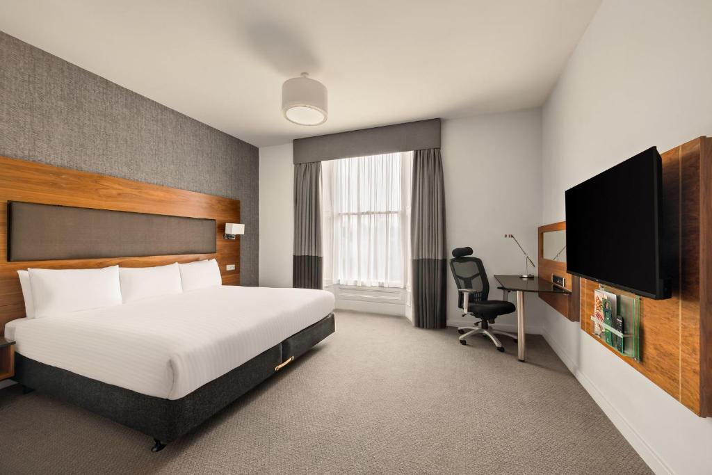 a hotel room with a bed and a desk at Holiday Inn Newcastle-Jesmond by IHG in Newcastle upon Tyne