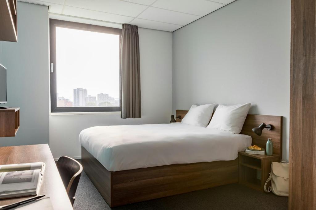 a hotel room with a bed and a window at The Social Hub Rotterdam in Rotterdam