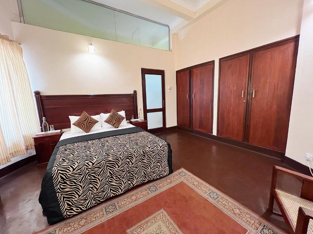 a bedroom with a bed and wooden cabinets at The Deane Residence Double Room in Colombo