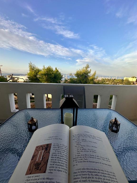 an open book sitting on a table on a balcony at ElRodia Sea View in Kipséli
