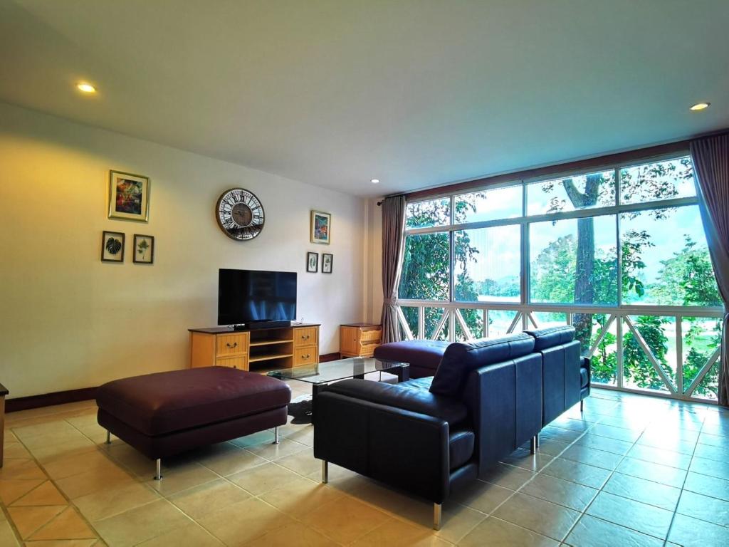 a living room with a couch and a tv at Trivista Khaoyai in Ban Khanong Phra Klang (1)