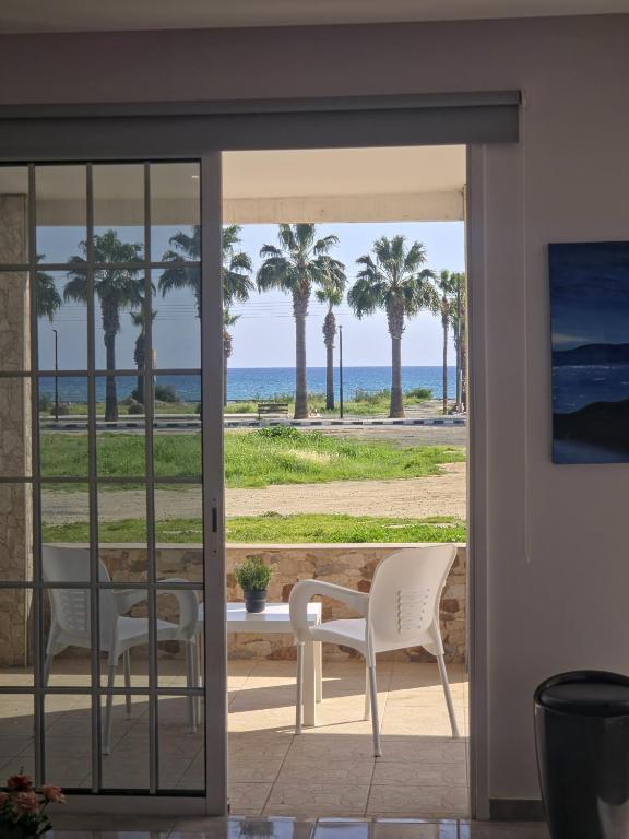 a room with a view of the beach and palm trees at 2 bedroom home sea view in Pyla