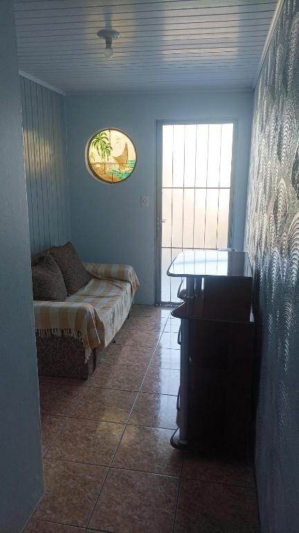 a room with a bed and a table and a window at Casa simples e arejada in Caxias do Sul