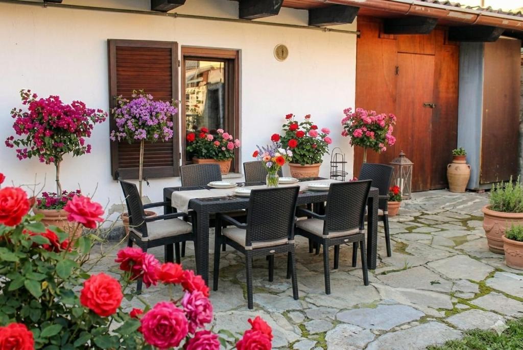 a patio with a table and chairs and flowers at Jolie Maison in Châtillon