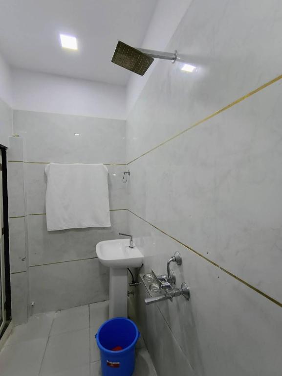 a white bathroom with a sink and a towel at Hotel Suraj Palace And Restaurant in Rūpaheli