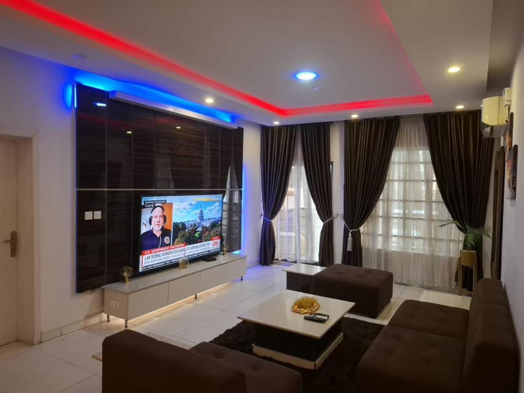a living room with a couch and a tv at Presken Apartment Ikoyi in Lagos