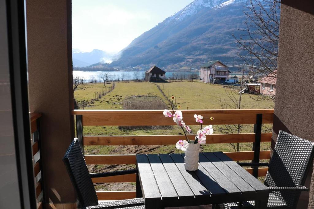 a table with a vase of flowers on a balcony at Apartments Kenan in Plav