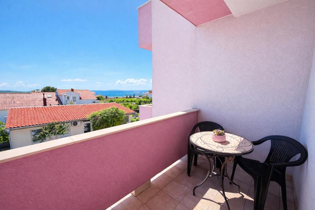 a small table and chairs on a balcony with a view at Apartmani Čop Rab in Banjol