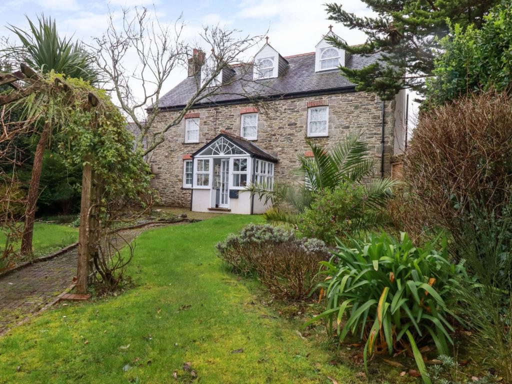 an old stone house with a garden in front of it at Vosporth Villa in Newquay