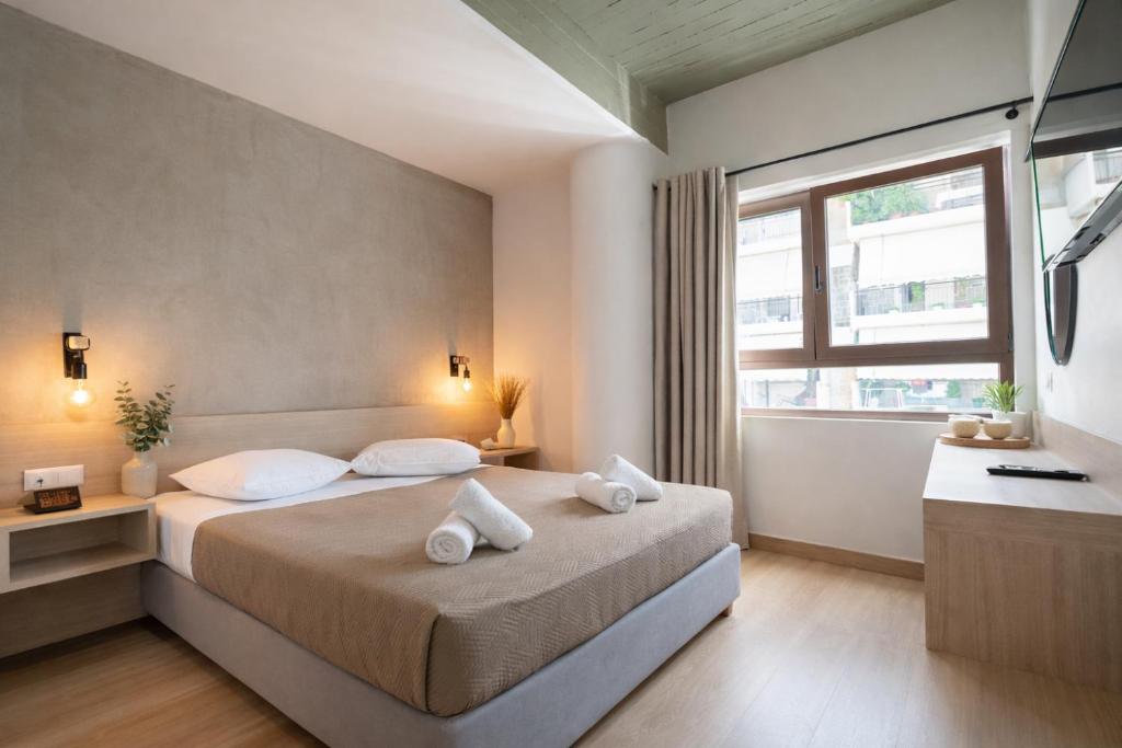 a bedroom with a bed with white pillows and a window at Athens Hawks Urban in Athens