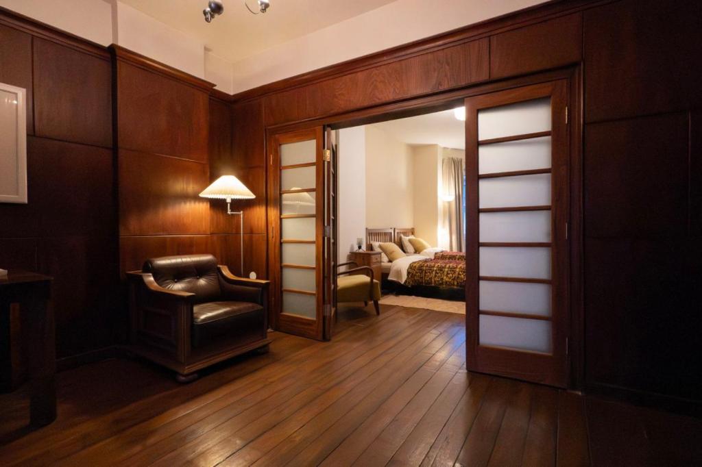 a room with a door and a chair and a bedroom at GLEDKA Apartament in Veliko Tŭrnovo