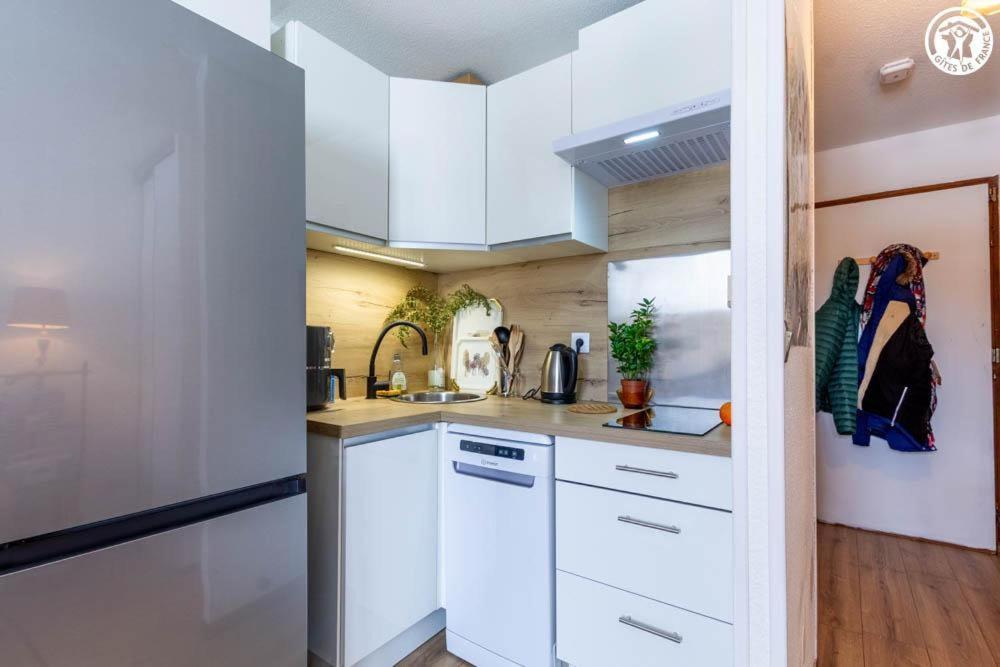 a kitchen with white cabinets and white appliances at Dans les mélèzes in Saint-Pancrace