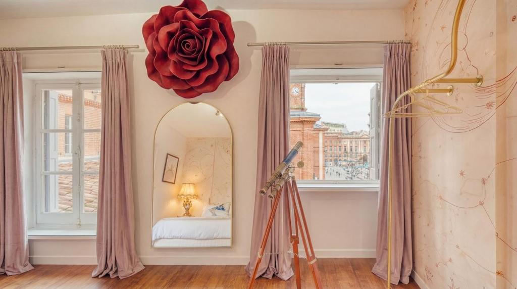 a room with a mirror and a red rose on the wall at La Planète 612 - Vue Capitole in Toulouse