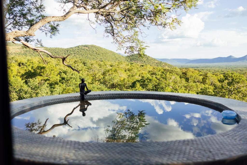 a person standing on top of a pool of water at Cypiro Leopard Lodge in Kransberg