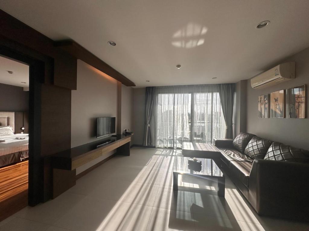 a living room with a couch and a television at Boat Avenue Apartment in Bang Tao Beach