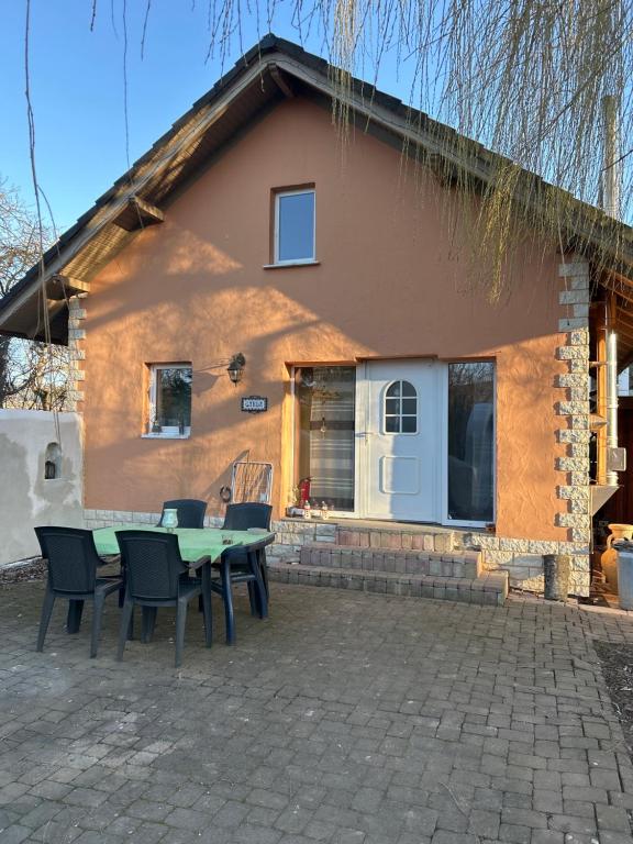 a house with a table and chairs in front of it at Ferienhaus Garda Hundefreundlich großer Garten Terrasse WLAN in Günthers