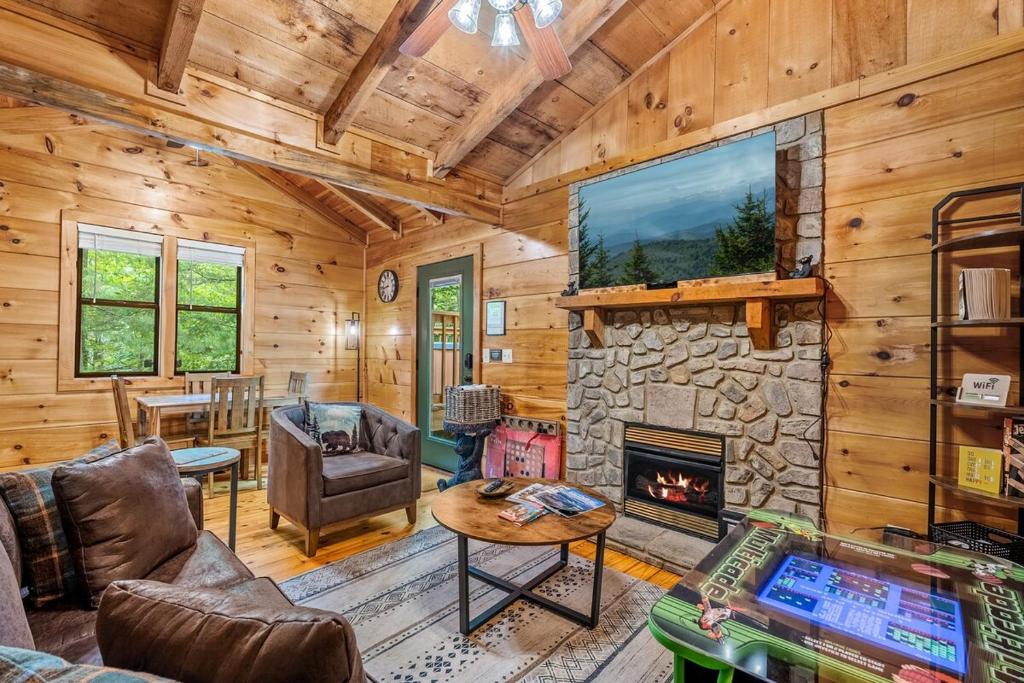 a living room with a fireplace and a tv at Tennessee Whisper Cabin in Sevierville