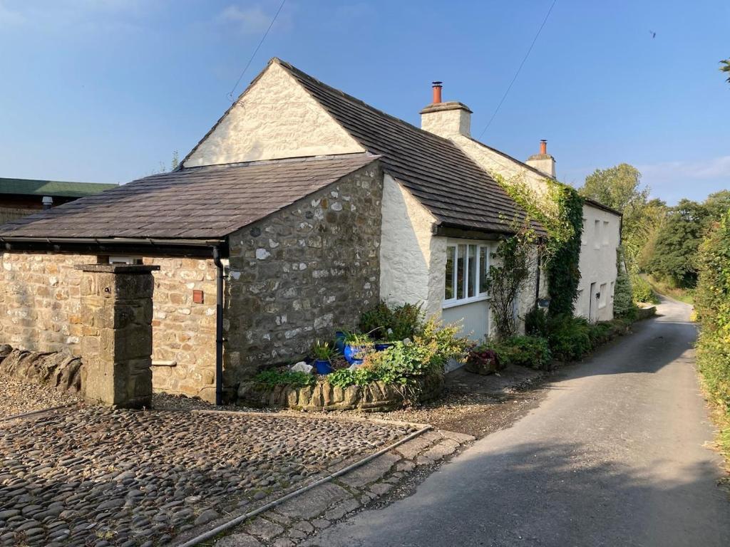 a small stone house with a pathway next to it at The Studio Gressingham in Hornby