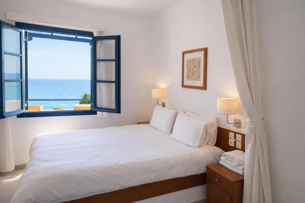 a bedroom with a bed with a view of the ocean at Endless Blue Studios in Myrtos