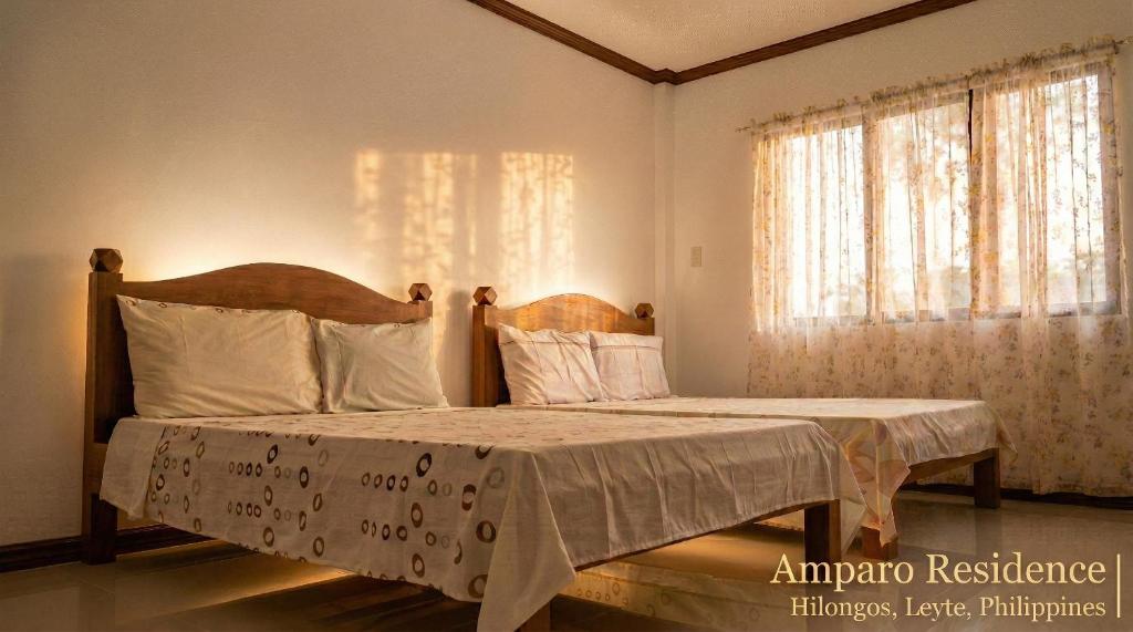 a bedroom with two beds and a window at Amparo Residence, Arayat Room in Hilongos