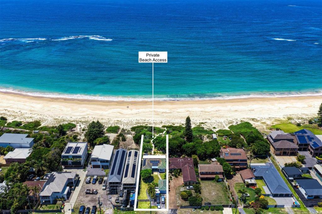 an aerial view of a beach with houses and the ocean at Garrys After Dunes Delight in Norah