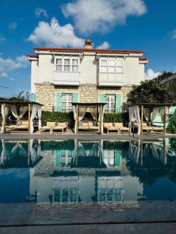 a house with a pool in front of a building at Boreas Otel Alaçatı in Alaçatı