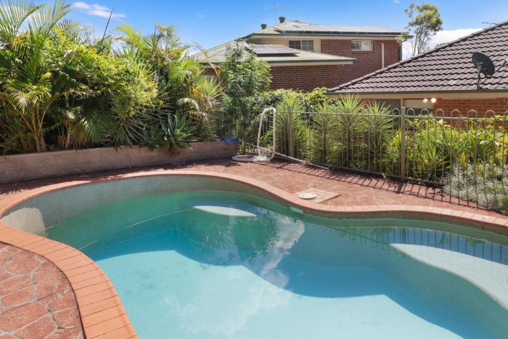 a swimming pool in a yard with a fence at Play and Pool Bonnells Bay in Bonnells Bay