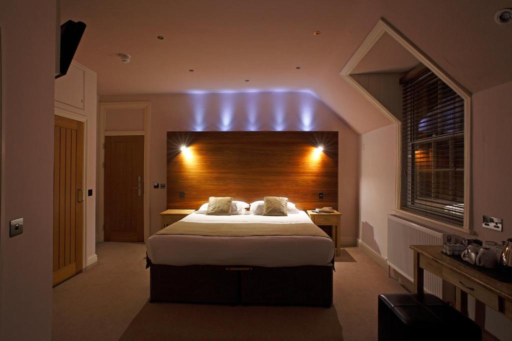 a bedroom with a large bed with a wooden headboard at Castle Hotel in Aberystwyth