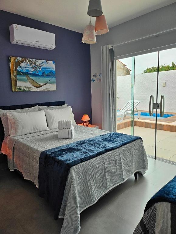 a bedroom with a large bed and a swimming pool at Casa piscina privativa e Área Gourmet - Condomínio 24 hs in Araruama