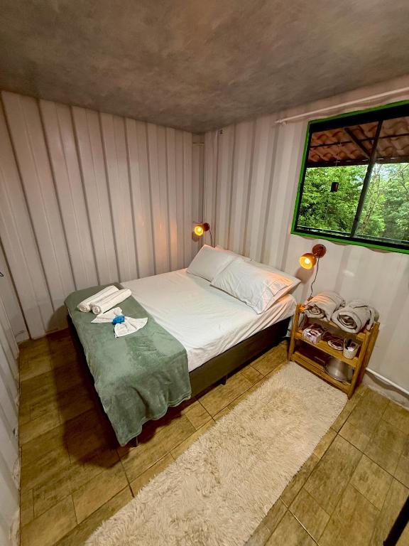 a small bedroom with a bed and a window at Cipó Container in Santana do Riacho