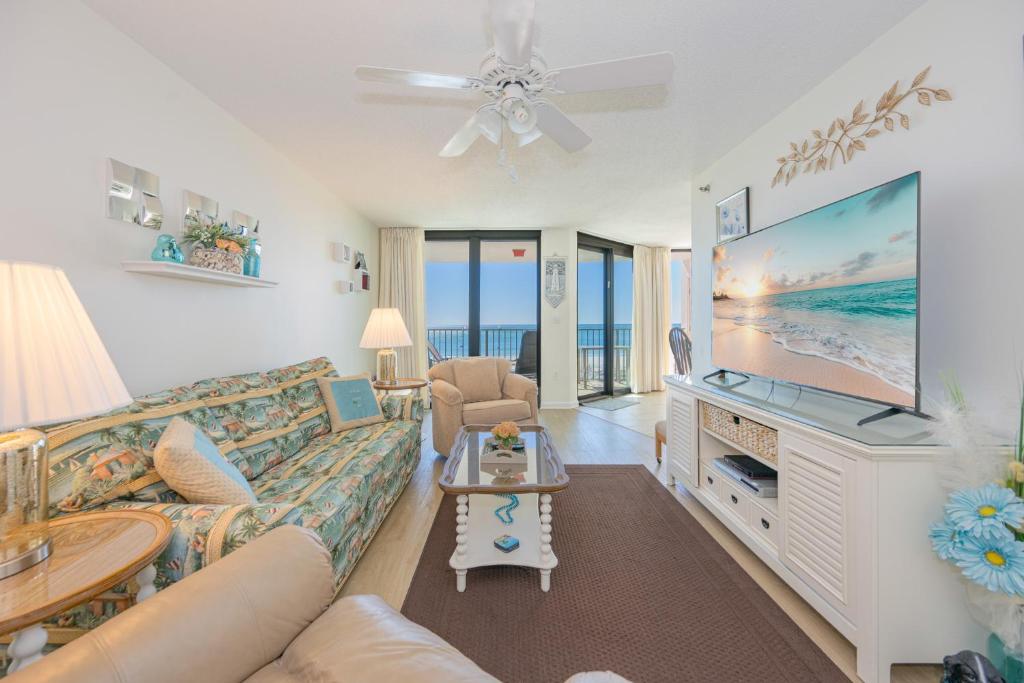 a living room with a couch and a tv at Phoenix East II 2032 in Orange Beach
